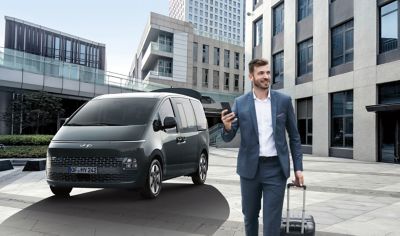 Business man walking away from the all-new Hyundai STARIA with smart power tailgate.