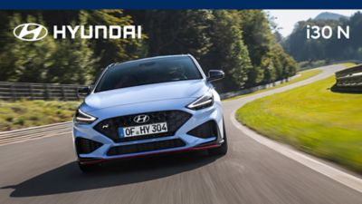 Vista frontale di Nuova Hyundai i30 N in Performance Blu in corsa su pista.