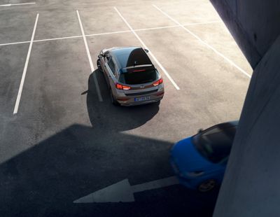 Vue arrière de Hyundai i30 en marche arrière sur un parking vide.