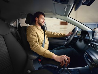 A man in a light brown sweatshirt driving the all-new Hyundai i20, co-driver's perspective