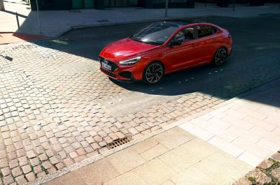 A Hyundai i30 Fastback N Line parked on a cobblestone street.