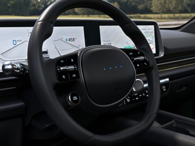 Le volant avec indicateurs LED à l’intérieur de la Hyundai IONIQ 6 électrique avec éclairage d’ambiance bicolore bleu.