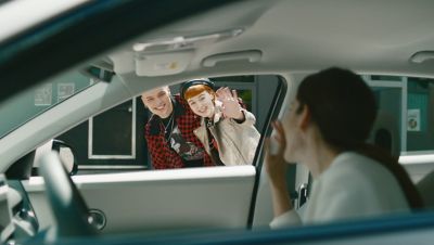 Due ragazzi salutano ragazza all'interno di Nuova Hyundai IONIQ 5
