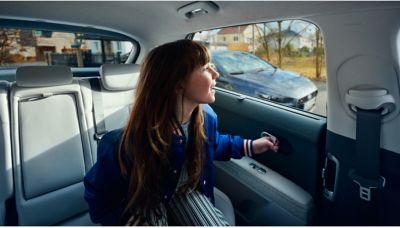 A child in the back of the Hyundai IONIQ 5 with safe exit assist.