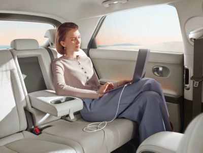 A tablet charging with the Hyundai IONIQ 5 electric midsize CUVs Vehicle-to-Load technology.
