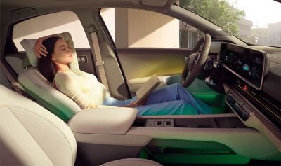 Donna appoggiata ai sedili relax della parte anteriore di Hyundai IONIQ 6 berlina coupé 100% elettrica