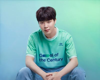 BTS member Jimin wearing a  Hyundai Team Century shirt with Goal of the Century on the front.