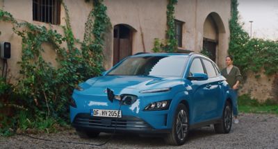 Il SUV Nuova Hyundai KONA Electric parcheggiato davanti ad abitazione in carica
