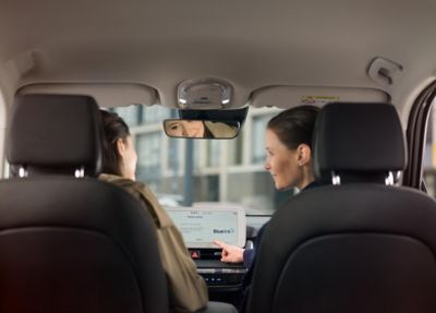 Doradca serwisowy Hyundai pokazuje aplikację Bluelink na ekranie centralnym wewnątrz samochodu.
