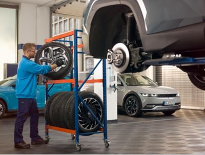 A Hyundai technician changing the tyres of a Hyundai IONIQ Electric vehicle.