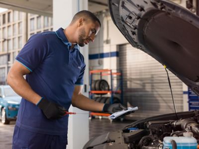 Repair Situation with a spanner in the front and a person working on the car in the background.