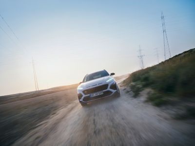 Nový Hyundai KONA N v barevném provedení Sonic Blue na štěrkové silnici. 