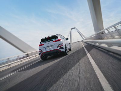 ‘Hot SUV’ Hyundai KONA N in achteraanzicht terwijl hij over een brug rijdt.