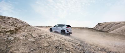 Hyundai KONA N driving on an unpaved road in an open landscape