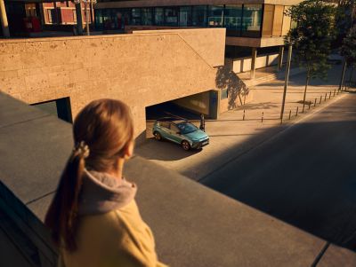 Topview of the Hyundai BAYON compact crossover SUV driving out of a parking garage.