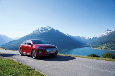 Hyundai IONIQ Electric kjører ved en fjord. Foto.