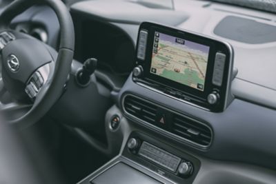 Nawigacja wyświetlana na ekranie centralnym we wnętrzu modelu Hyundai KONA Electric.