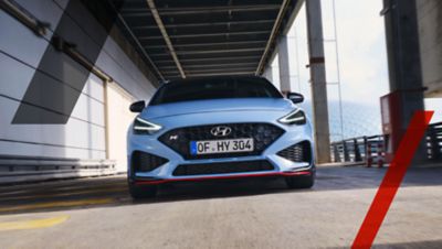 The Hyundai i30 N from the front driving down the street.