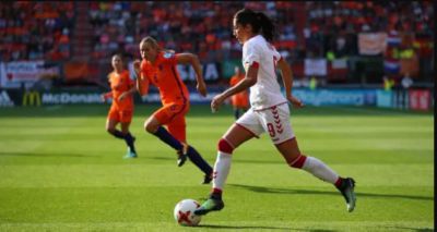 Nadia Nadim, jugadora de la selección danesa de fútbol moviendo el balón en el campo contra Holanda.