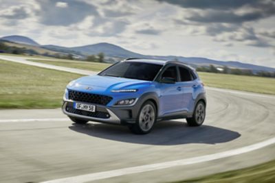 Niebieski Hyundai KONA jadący po drodze.