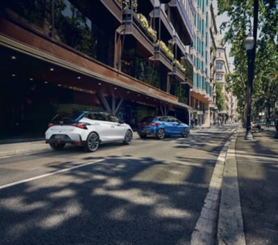 Nuova Hyundai i20 N Line parcheggiata in una strada sgombra accanto un grande edificio.