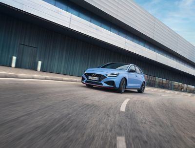 La nuova berlina ad alte prestazioni Hyundai i30 N in Performance Blu che sfreccia in curva