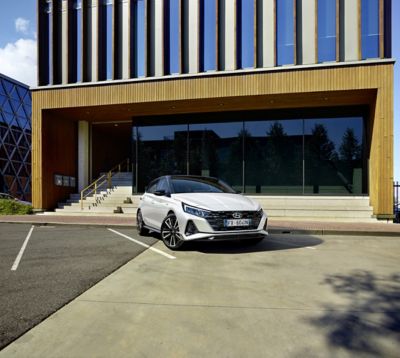 Nuova Hyundai i20 N Line parcheggiata di fronte a edificio industriale