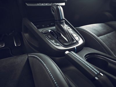 The leather-covered gear knob and parking break with accent stitching inside the Hyundai KONA N