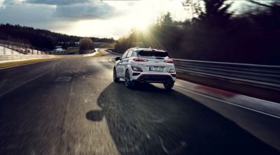 De Hyundai KONA N rijdt bij zonsondergang op een racecircuit.