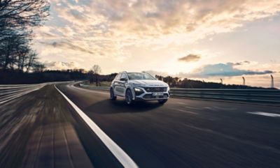 Hyundai KONA N évoluant sur une piste de course au coucher du soleil.