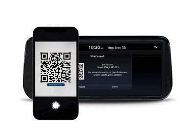 Hyundai-display en een smartphone die het updatescherm van het Infotainment-updateportaal weergeeft