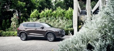 Nuova SANTA FE Plug-in Hybrid, il SUV a 7 posti di Hyundai parcheggiato davanti a un’abitazione
