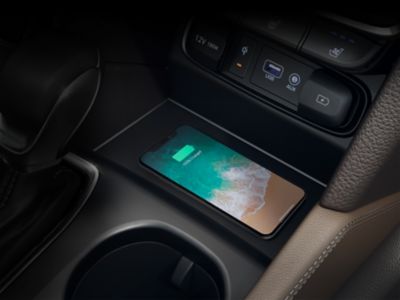 Een Qi-enabled smartphone in een draadloos oplaadbakje van een Hyundai middenconsole.