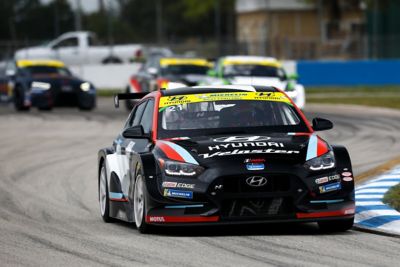 The Hyundai Motorsport’s i30 N TCR in action on a racetrack pictured from the front.