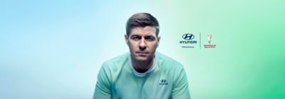Piłkarz Steven Gerrard na niebiesko-zielonym tle i logo Hyundai X FIFA.