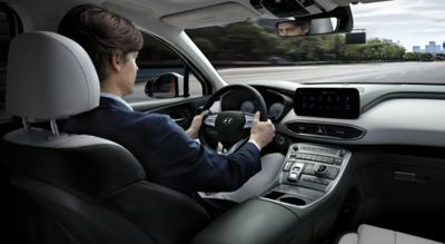 Interior view of the new Hyundai Santa Fe 7 seat SUV showing a man driving down the highway.