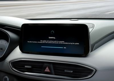 A centre touch screen inside a Hyundai vehicle with the screen showing a software update.