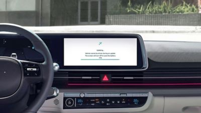Un écran tactile central à l’intérieur d’un véhicule Hyundai avec l’écran affichant une mise à jour logicielle.