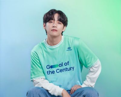 BTS member V wearing a  Hyundai Team Century shirt with Goal of the Century on the front.