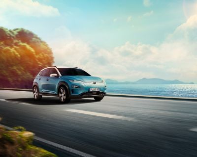 Hyundai KONA Electric corre su strada che costeggia specchio d'acqua