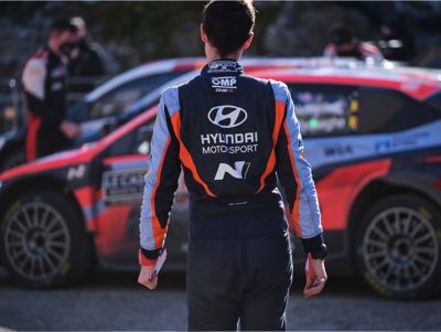 Hyundai Motorsport driver walking towards the Hyundai i20 N WRC Rally1.