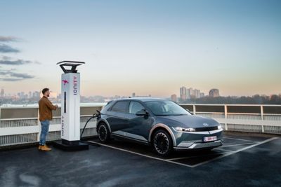 A Hyundai IONIQ 5 electric vehicle charging at IONITY high-power charging station.