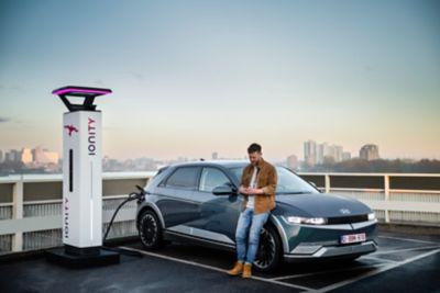 The Hyundai IONIQ 5 EV parked at the beach with two surfers leaving the car.