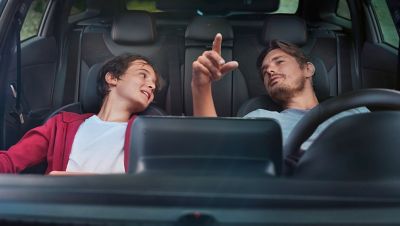 Two people sitting inside a Hyundai vehicle.
