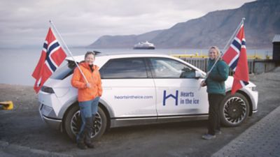 Sunniva Sørby og Hilde Fålun Strøm i Hearts in the Ice foran sin elbil IONIQ 5. Foto.