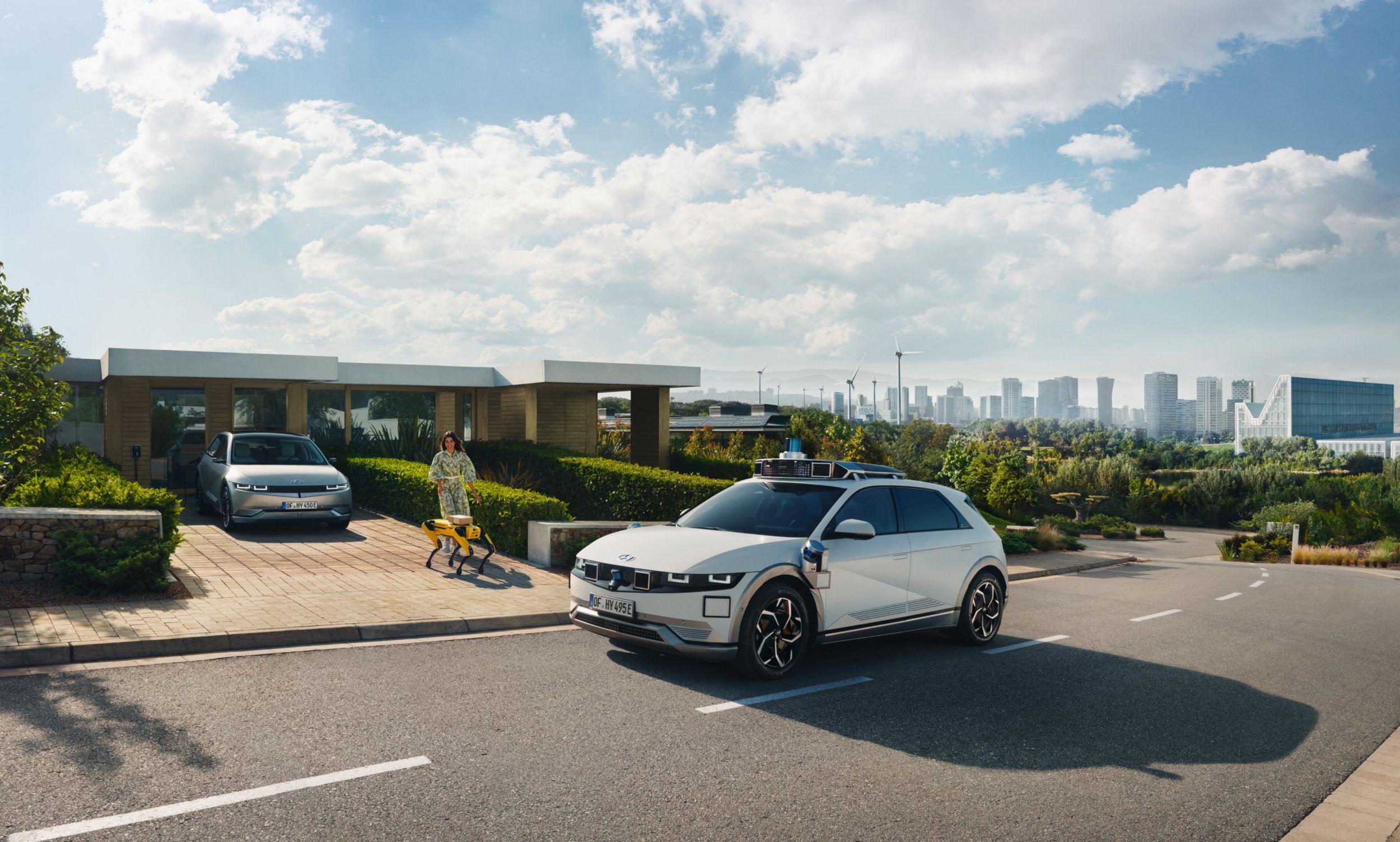 Visión de futuro de Hyundai con un robotaxi IONIQ 5 y el robot Spot repartiendo correspondencia