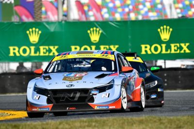 Une photo de la customer racing VELOSTER N TCR de Hyundai Motorsport en action sur un circuit illustré du côté