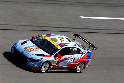 Une photo de la customer racing VELOSTER N TCR de Hyundai Motorsport en action sur un circuit illustré du côté