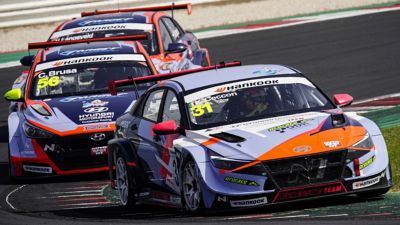 Hyundai Motorsport customer racing Elantra N TCR in action on a racetrack shown from the front.