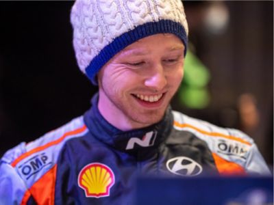Hyundai Motorsport driver Oliver Solberg smiling with a hat on.